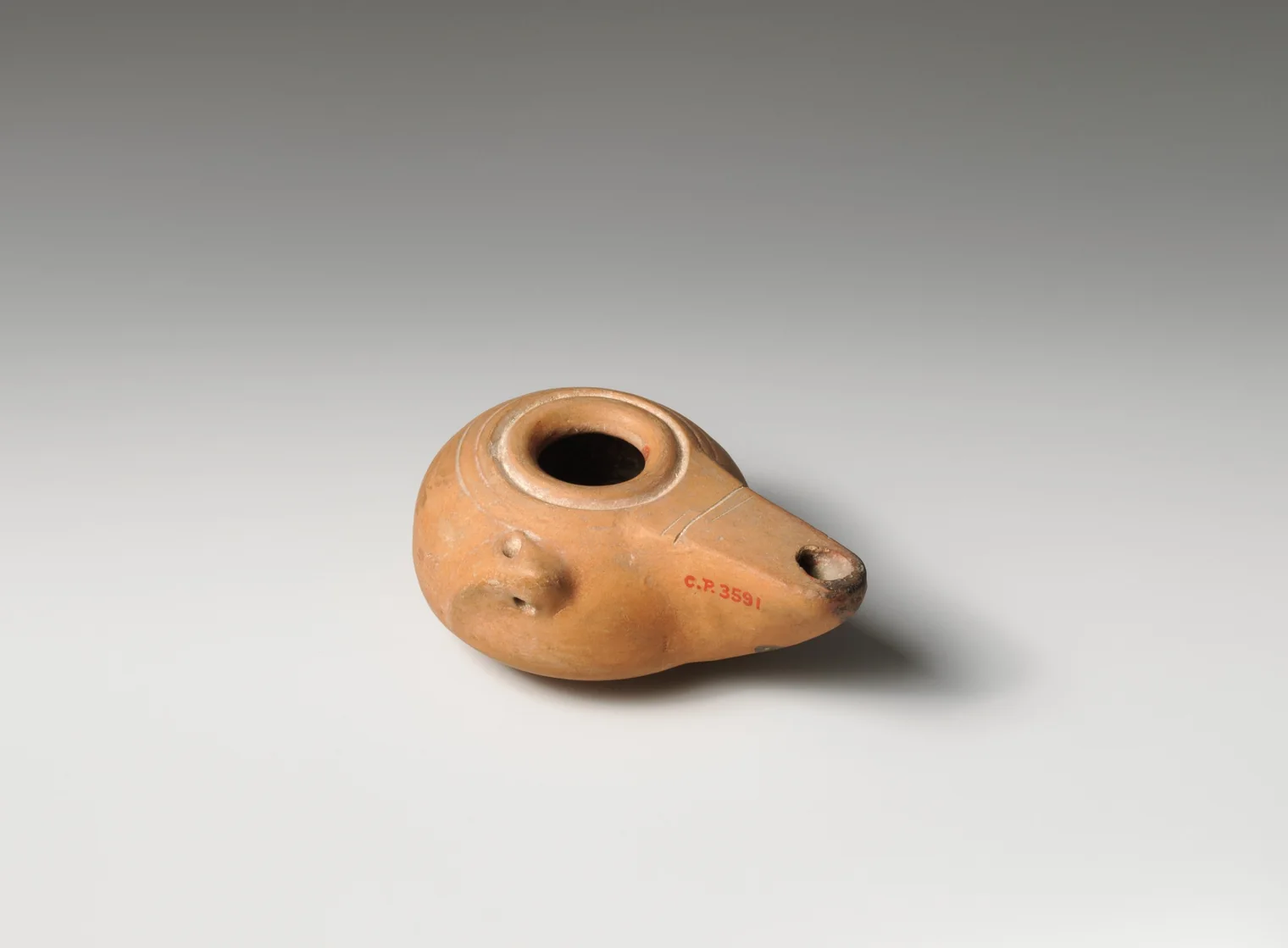 Lucerna griega helenística de terracota con depósito de aceite y pico para la mecha