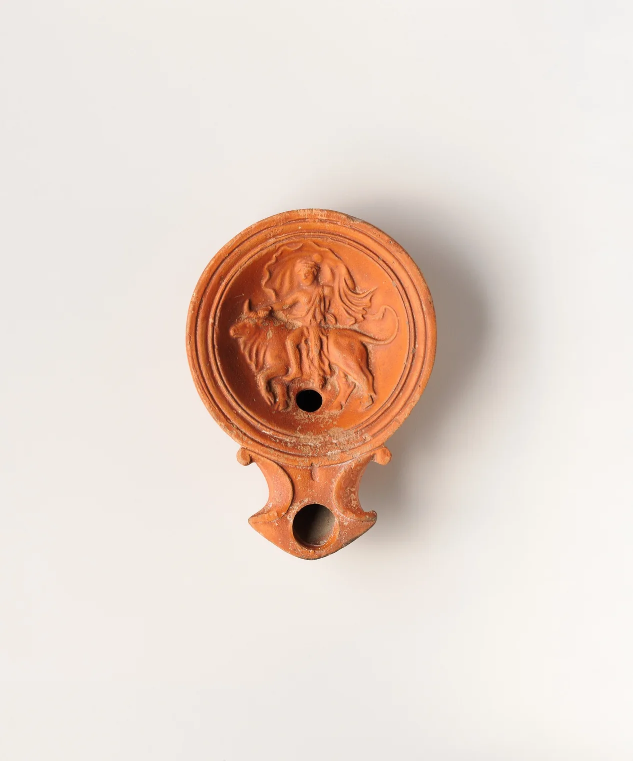 Vista superior de lucerna romana con relieve de Europa y el toro