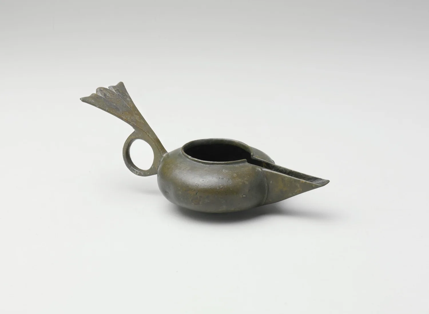 Lucerna de aceite de bronce de Nishapur con pico, depósito y asa alada, vista lateral
