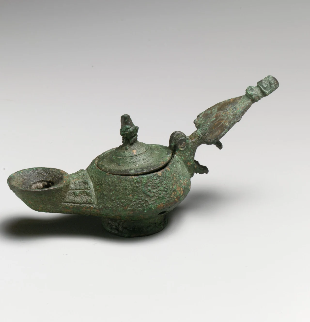 Lámpara romana de bronce con tapa y asa, hacia el siglo IV d. C., conservada en The Metropolitan Museum of Art