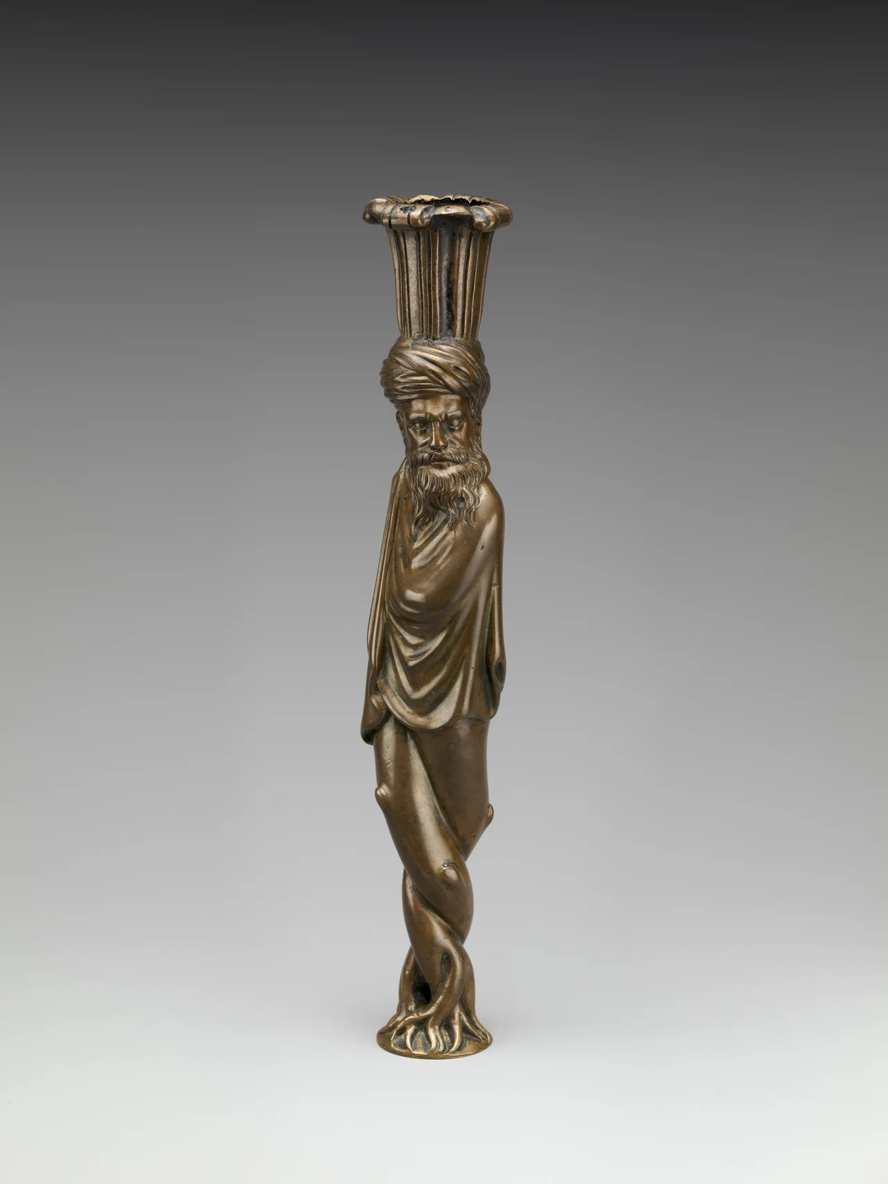 Candelero alemán figurativo de finales del siglo XVI en latón, con portavelas sobre una figura con turbante